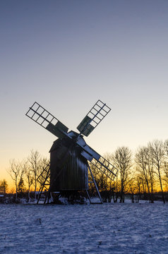 Wooden windmill by sunset in winter time