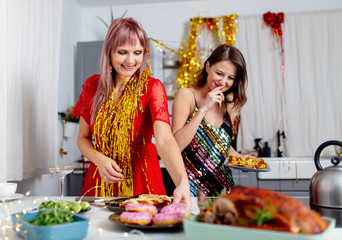 two girls having fun with donuts in the kitchen after a party