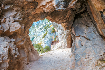 Interior of a tunnel on the trail in the Picos de Europa, on the route of Cares. Asturias, vertical photo