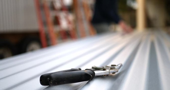 A pair of sheet metal tin snips on building materials at a construction site.