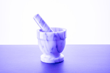 Manual bowl for grinding black pepper purple background