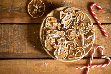 Christmas gingerbread on wooden plate on kitchen old table
