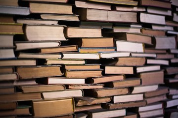 A huge pile of different books in the library. A library full of books. Reading. A huge number of books of different genres and sizes. Studying and education. Knowledge.