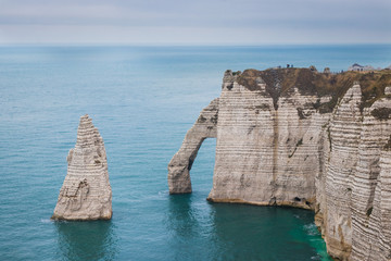 Panoramatic view on Etretat steep rock coastal cliffs at north of France, served as many...