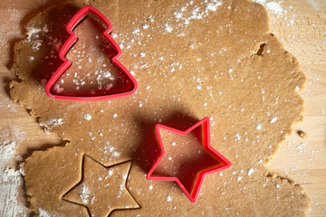 Dough for Christmas gingerbread and cookie cutters on wooden table