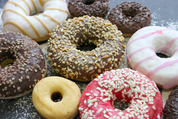 Various donuts on white background, from above. 