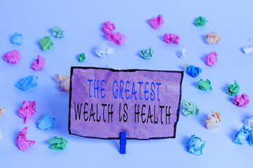 Text sign showing The Greatest Wealth Is Health. Business photo text being in good health is the prize Take care Colored crumpled papers empty reminder white floor background clothespin