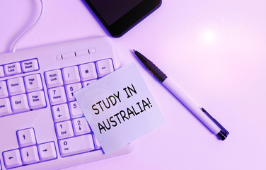 Handwriting text writing Study In Australia. Conceptual photo going into foreign country order complete your studies White pc keyboard with empty note paper above white background