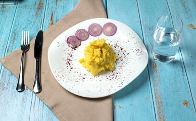 Mashed potatoes in bowl with onion on the table