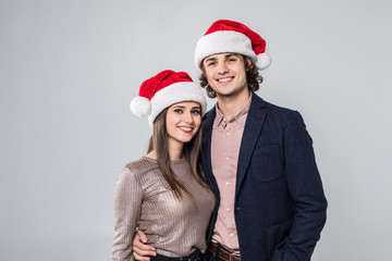 Young happy couple in Christmas hats isolated over white background