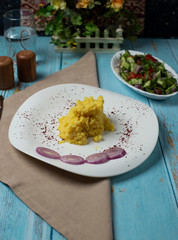 Mashed potatoes in bowl with onion on the table