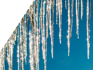 Icicles sparkling in the briht sunlight on blue sky background