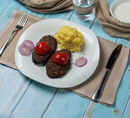 Breaded pork cutlet with potatoes, onion, tomatoes