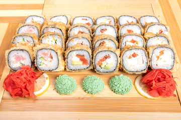 Set of baked rolls with various fillings. Close up with ginger and wasabi.