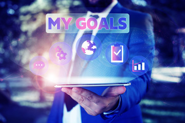 Text sign showing My Goals. Business photo showcasing Future or desired result that a demonstrating commits to achieve Male human wear formal work suit presenting presentation using smart device