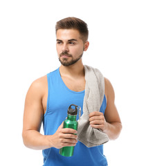 Sporty young man with towel and bottle of water on white background