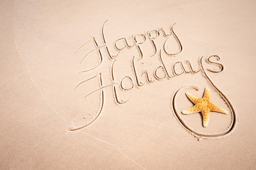 Tropical Happy Holidays message handwritten in calligraphy script with natural starfish on smooth...