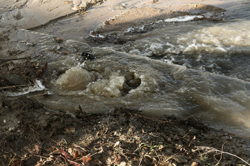Emergency Sewerage. Water flows down the sidewalk from a ruptured underground sewer pipe. The...