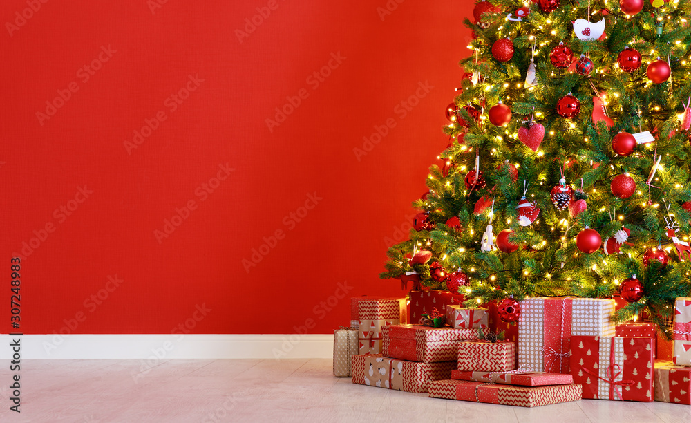 Wall mural christmas tree on the background of red empty wall.