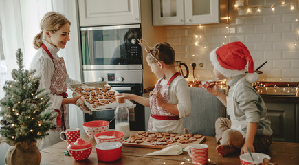 happy family mother and children bake christmas cookies.