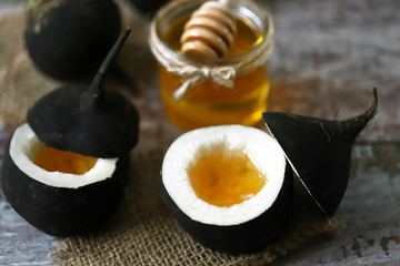 Black radish. Black radish with honey. Natural cure for colds and coughs. Healthy recipes concept. Selective focus. Macro.