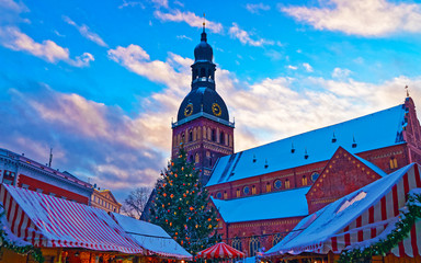 Cityscape with Christmas Market at Dome Cathedral square in Winter Riga, Latvia. Advent Fair Decoration and Stalls with Crafts Items on the Bazaar. Latvian street Xmas and holiday