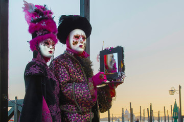  Masks at the Venice Carnivalm Italy, with mirror in hand