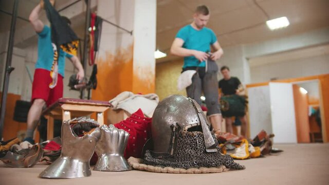 Men knights training in the gym - equipment for the knights battle lying on the floor