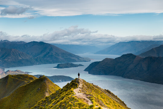 Roys peak mountain hike in Wanaka New Zealand. Popular tourism travel destination. Concept for hiking travel and adventure. Scenic view over lake from mountains peak. New Zealand landscape background.