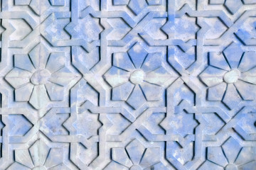 The texture on the concrete surface is blue, close up. Background of flowers Arabic style. Texture with African pattern on the stone wall.