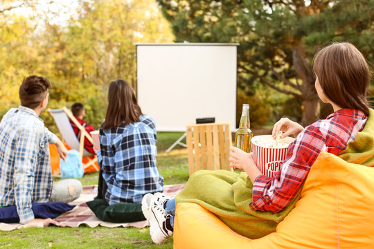 Friends Watching Movie In Outdoor Cinema