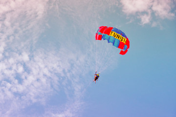 Parachute with people over the sea. Entertainment on the beach in Tunisia.