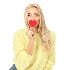 Beautiful young woman with small red heart on white background