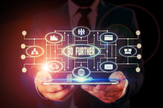 Handwriting text writing Go Further. Conceptual photo To move to a greater distance or overcome your limitations Male human wear formal work suit presenting presentation using smart device
