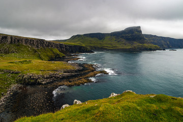 View on green grass filled coastal in Scotland near Nest Point famous lighthouse, Isle of Skye