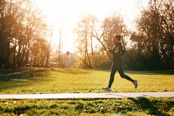 Obraz na płótnie Canvas Dedicated African American female athlete running in the park.