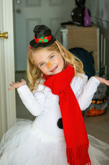 Little blonde girl in a snowman suit and festive Christmas hat