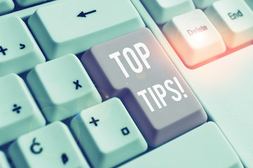 Conceptual hand writing showing Top Tips. Concept meaning small but particularly useful piece of practical advice White pc keyboard with note paper above the white background