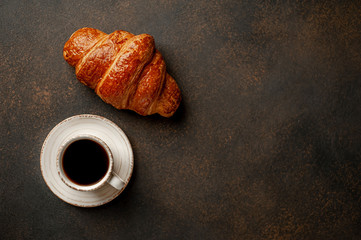 coffee and croissant on a stone table with copy space for your text, early breakfast concept