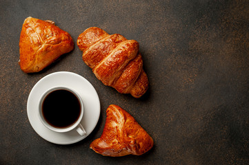 coffee and croissant buns on a stone table, with copy space for your text, early breakfast concept