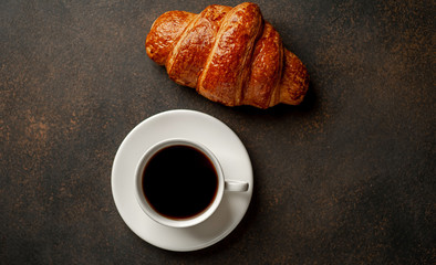 coffee and croissant on a stone table with copy space for your text, early breakfast concept