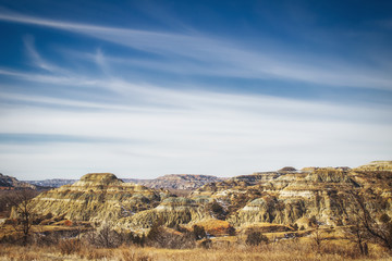 Multi layered colorful rock mountains in the Black Hills under a blue wispy sky in a springtime South Dakota landscape