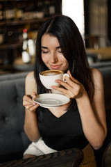 Beautiful woman drinking coffee sitting in a cafe.