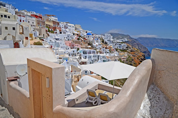 Oia town on Santorini island, Greece. Traditional and famous white houses and churches with blue domes over the Caldera, Aegean sea.