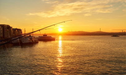 Fototapeta na wymiar Silhouettes of fishermen fishing on Galata Bridge to relax and enjoy their hobby in Istanbul