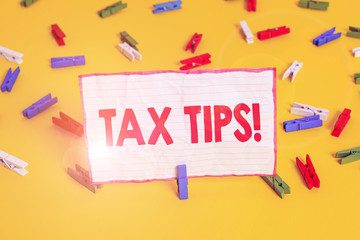 Conceptual hand writing showing Tax Tips. Concept meaning compulsory contribution to state revenue levied by government Colored clothespin papers empty reminder yellow floor office