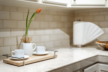 White Counter with coffee cups and a tulip in vase