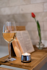 Wine a candle, book and tulip in bathtub