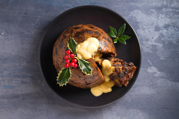 Christmas pudding decorated with sprig of holly. Cristmas decorations. View from above, top