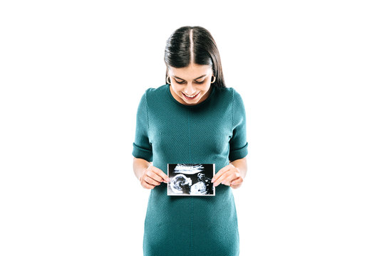 smiling pregnant girl holding fetal ultrasound image isolated on white